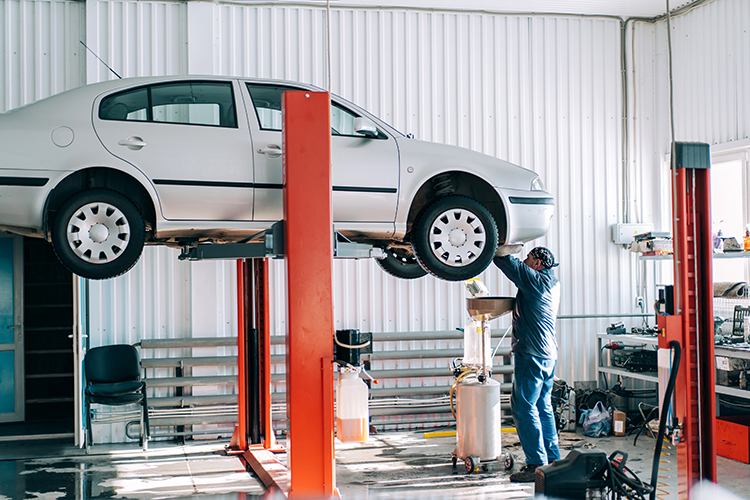 Car lifted on car lift for routine maintenance.