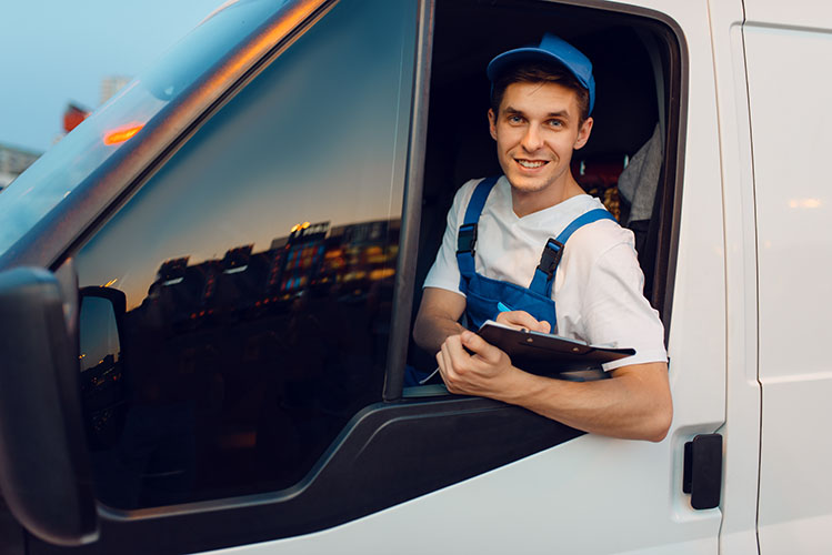 Deliveryman in uniform drives a car, delivery service, delivering. Man in post vehicle, male deliver, courier or shipping job